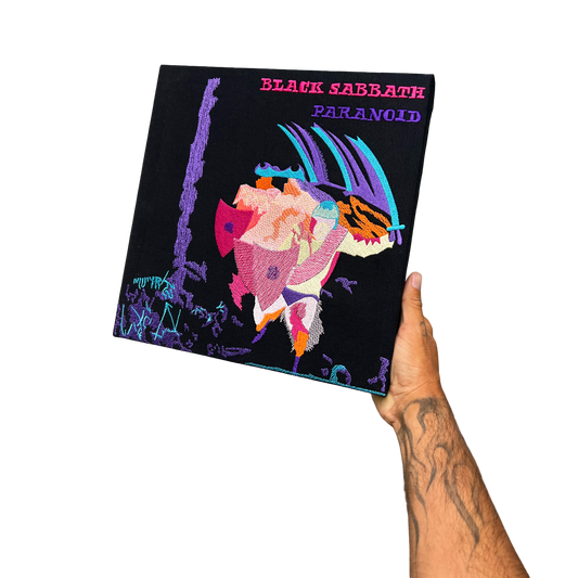 Hand holding a Black Sabbath 'Paranoid' album cover